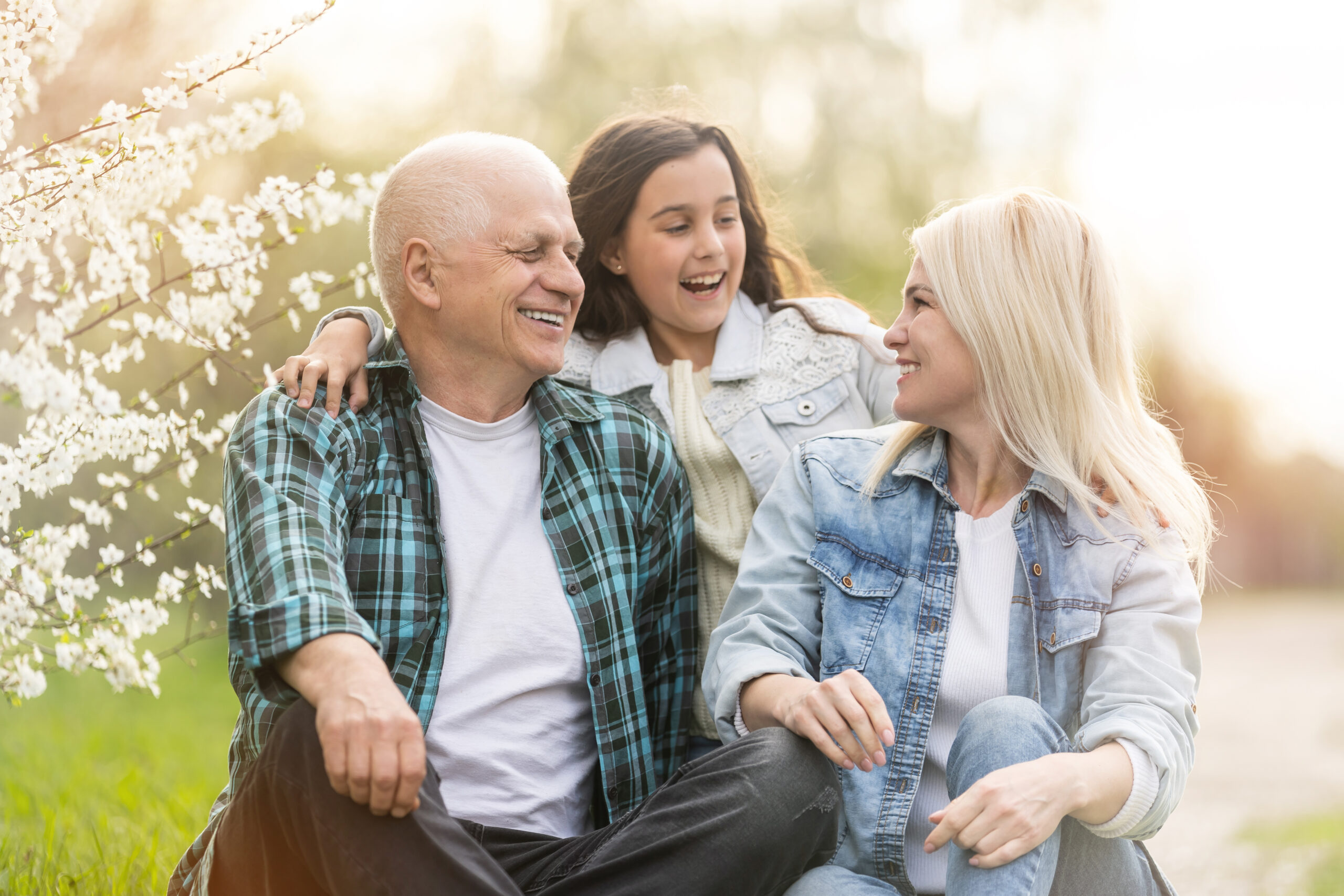 senior man grandfather sitting on outdoor in the park. Elderly retired male relax and enjoy outdoor activity together with daughter and granddaughter. Family relationship concept.