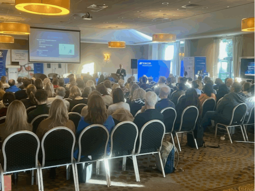 Solasta Healthcare team attending the Optometry Ireland AGM & Study Day 2025 at the Radisson Blu Hotel Limerick, with a large audience of optometrists listening to a presentation on cataract care and eye health innovation